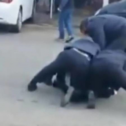 ВИДЕО - Бир адамды 3 милиционер кишендейт, артында - өрттөнүп жаткан унаа